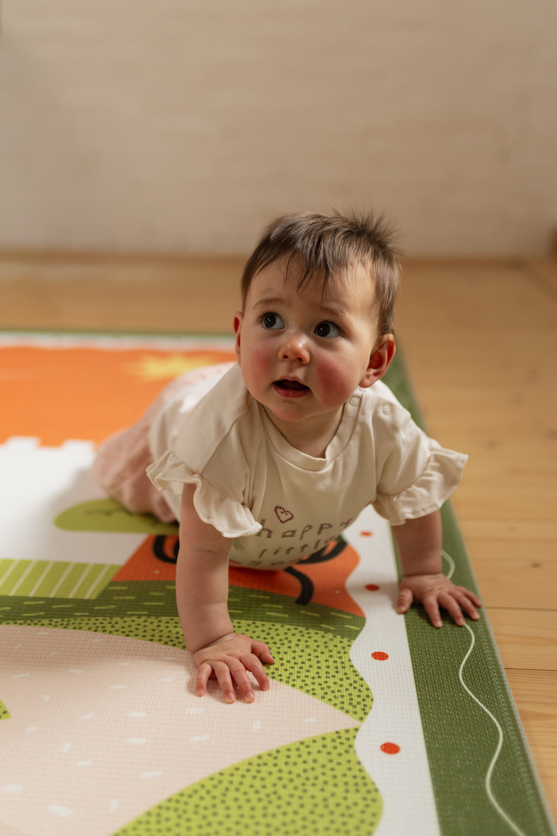 Little explorer girl crawling on the playmat