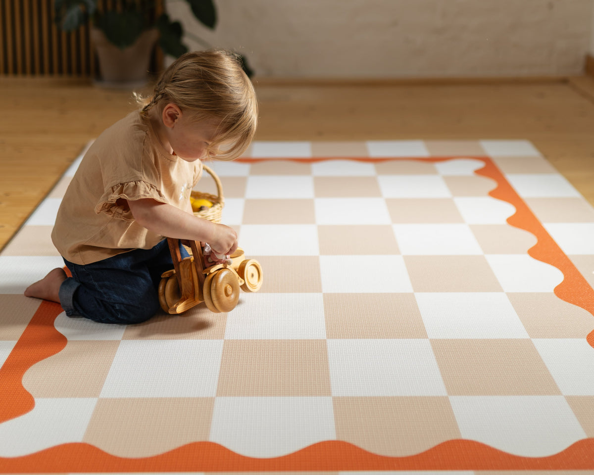 Rolly's texture Child playing with a toy on a checkered mat indoor