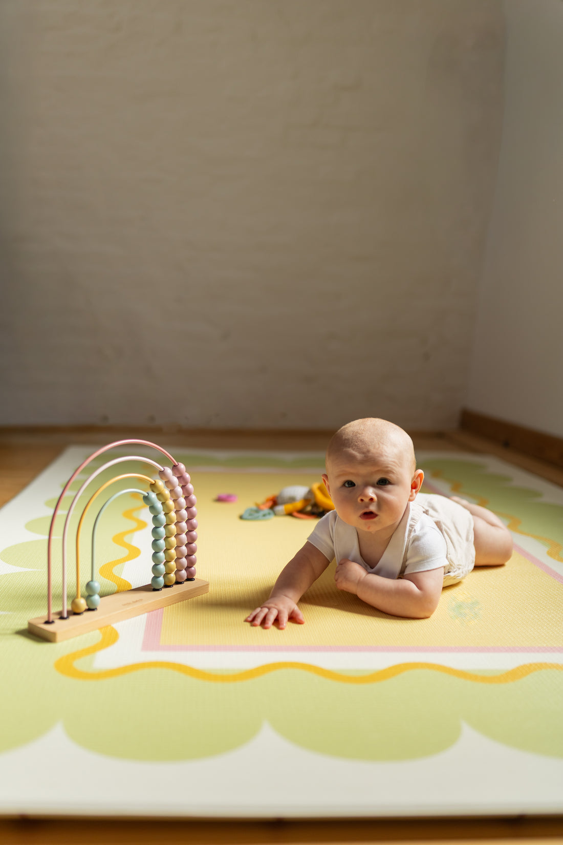 Tummy time with baby lying on a playmat