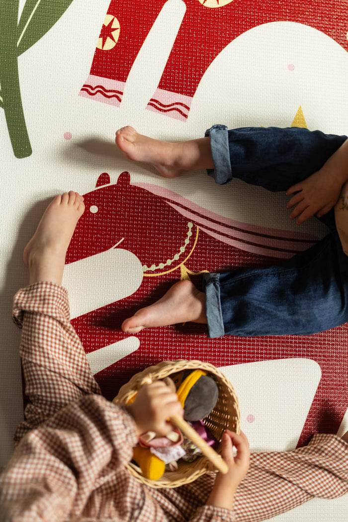 Two on-a-mat
Children playing on a patterned playmat with toys.